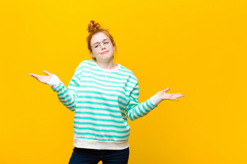 young red head woman feeling puzzled and confused, unsure about the correct answer or decision,...