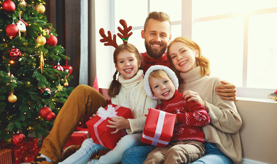 happy family with gifts near   Christmas tree at home.