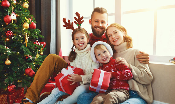 happy family with gifts near   Christmas tree at home.