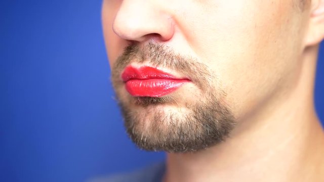 close-up. Bearded man with painted lips kisses a white rat