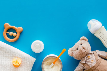 Baby food background with toys and accessories on blue table top view pattern frame copy space