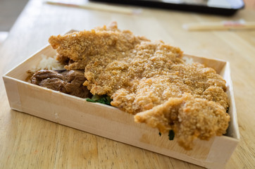 fried pork chop lunch box on the table