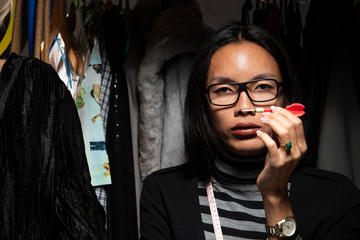 Fashion Designer black long hair checks order and growth sale on notebook computer. LBGT...