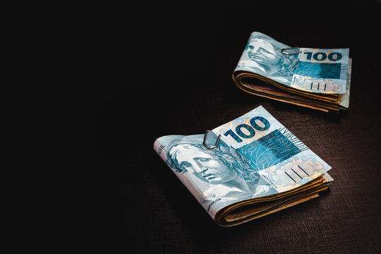 Brazilian money pack on isolated black background. Money from Brazil, called REAL, together on a black table. Concept of financial value or withdrawal from FGTS, banking.