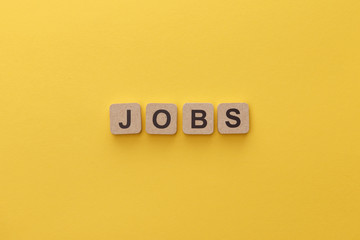 top view of cardboard squares with jobs lettering on yellow background