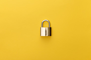 top view of metal padlock on yellow background - Powered by Adobe