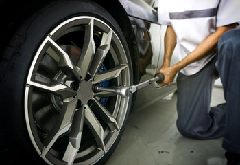 Auto mechanic using Torque wrench to inspection the wheel nuts for safety in travel in mechanics...
