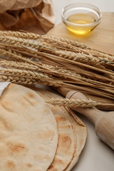 Fototapeta na wymiar lavash bread near rolling pin and cutting board with spikes and oil