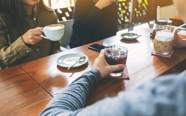 Closeup image of people enjoyed drinking coffee together in cafe