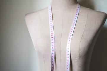 The tape measure is laid on the dressmaker's model.