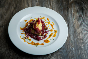 tasty roasted meat pieces with potato garnish and red onion