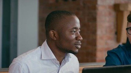Business Team Enjoy Eating Lunch Together at Workplace with Laptops. Diverse Group of Four People Eats Pizza and Discusses Project in Loft Office. 4K Gimbal Circling Medium Close up Shot