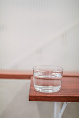 The bottle and clean glass of water on wooden background.selective focus, blur some part.
