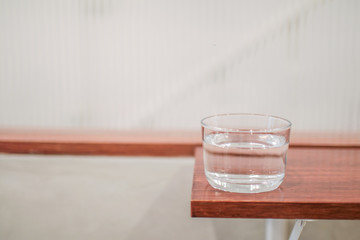 The bottle and clean glass of water on wooden background.selective focus, blur some part.