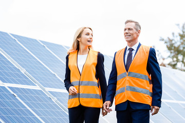 Obraz premium handsome businessman and attractive businesswoman talking and looking away