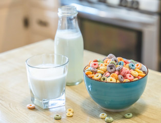 Bowl of colorful children's cereal and milk isolated on wood table with Text space