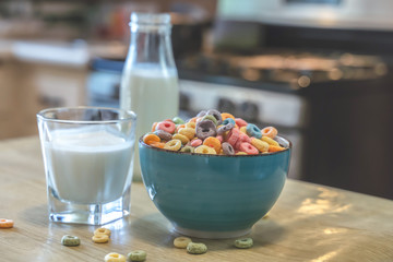 Bowl of colorful children's cereal and milk isolated on wood table with Text space