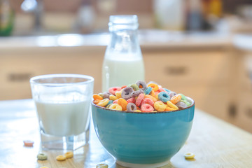 Bowl of colorful children's cereal and milk isolated on wood table with Text space