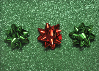 Festive colorful bows on sparkling glitter paper texture. Holiday background. Christmas concept.
