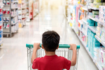 Cute little boy with a shopping car