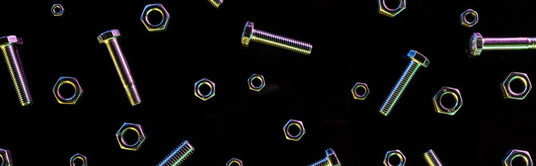 panoramic shot of scattered metal nuts and bolts pattern isolated on black
