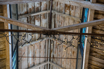 Close up of an old wooden ceiling strung with small white lights