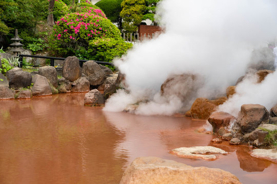 Streaming red hell poud , orange or Red Blood Hell Pond many big rocks surrounding in Beppu, Oita-shi, japan.