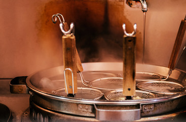 Obraz premium Hot boiling Ramen pot with noodle strainers and steam. Selective focus