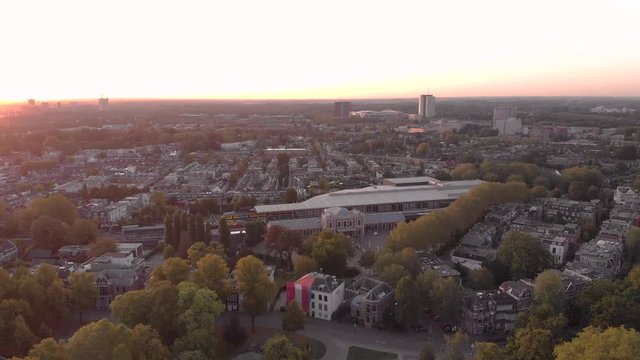 Aerial view the Dutch medieval city of Utrecht at sunrise with the white modern building of the railroad museum among the traditional homes