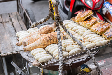 Banana and Sweet Potato Grilled traditional Thai style street food stall standing in Thailand