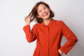 Portrait of happy beautiful Asian woman fixing hair