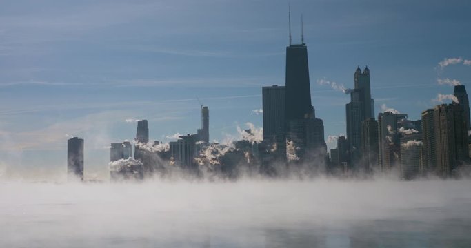 Downtown Chicago skyline during winter polar vortex. Close up view of fast drifting fog above Lake Michigan