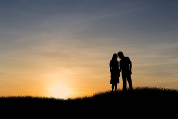 Fototapeta premium Silhouettes of couple man and woman in nature sunset background. Love concept.