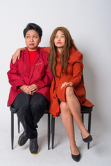 Mature Asian businesswoman looking stressed with weird Asian woman therapist as funny concept