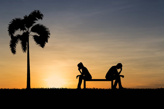 Silhouettes of couple man and woman broken heart at nature sunset. Love concept.