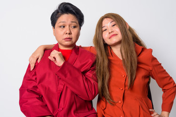 Mature Asian businesswoman looking stressed with weird Asian woman therapist as funny concept