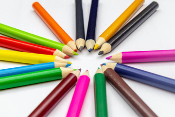 Fototapeta premium Many colored pencils arranged in a beautiful circle on a white background