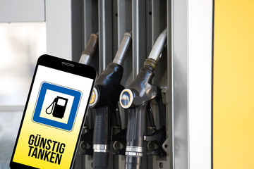 Eine Tankstelle, Smartphone und App für günstiges Tanken