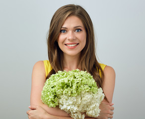 Close up face portrait of smiing woman holding flowers.