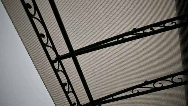 transparent polycarbonate roof on supports near the wall