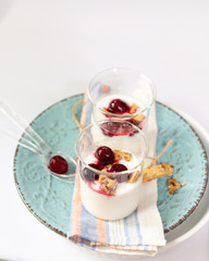Natural yogurt, cookies and cherries served. Healthy dessert. Portion desert in glass. Copy space.