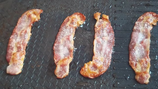 Slow motion of Bacon sliced frying on pan