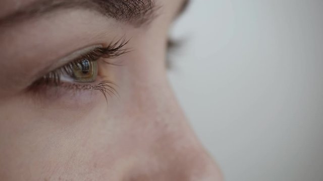 Close-up view on woman blinks and looks away.