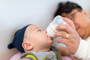 Father holding and feeding his baby