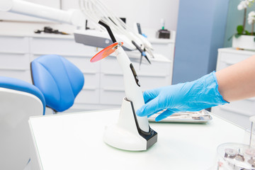 A doctor's hand holding a polymerization UV lamp. Polymerization lamp.