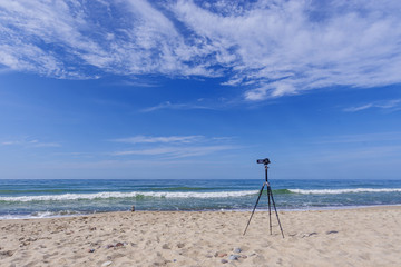 The camera stands on the beach of the summer sea. The photographer's dream about his work.