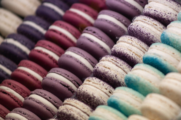 Colorful cakes macaron aka French macarons lie on the counter. Multi-colored macarons lie in rows.