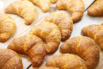 Fresh baked croissant pastry on sale in cafe. Buy tasty bakery product for coffee break. Sweet dessert food.