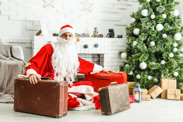 Christmas Santa Claus with suitcases at his home. Christmas, New Year.