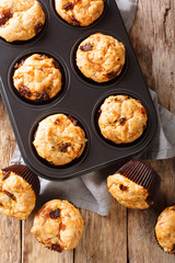 muffins with sun-dried tomatoes and cheddar cheese close-up in a baking dish on the table. Vertical top view from above